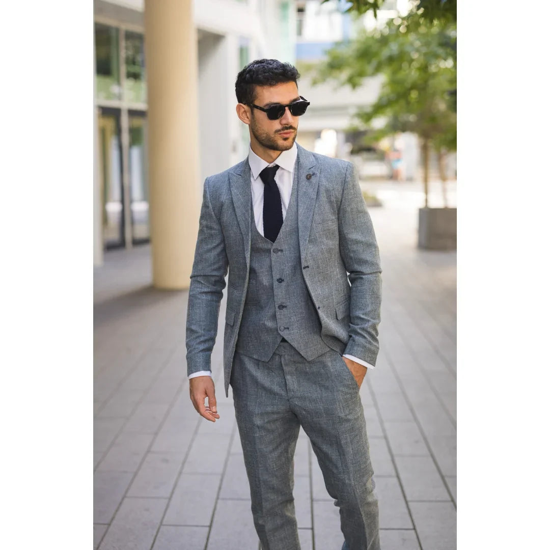 Man wearing a gray suit and sunglasses on a city street